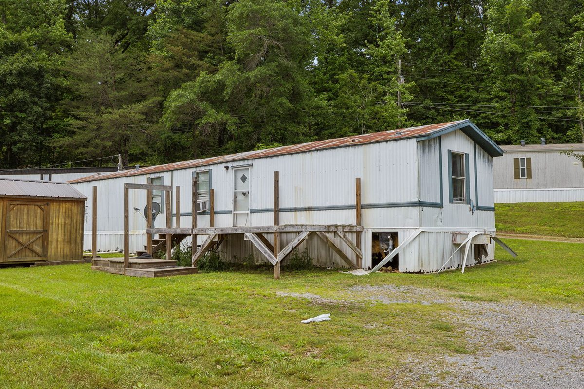 Single-wide home with metal underpinning and rear privacy fence
